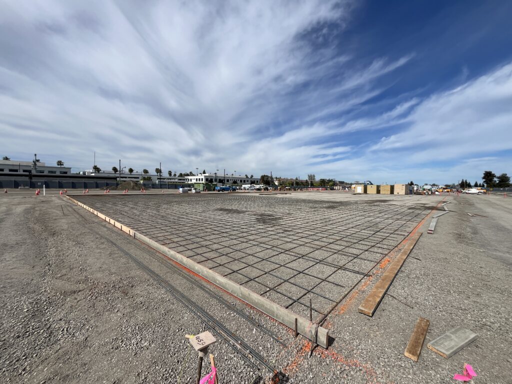 Temporary concrete slab being constructed to support future excavation walls.