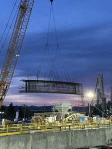 A Caterpillar shaft top strut rebar cage is lifted by a crane