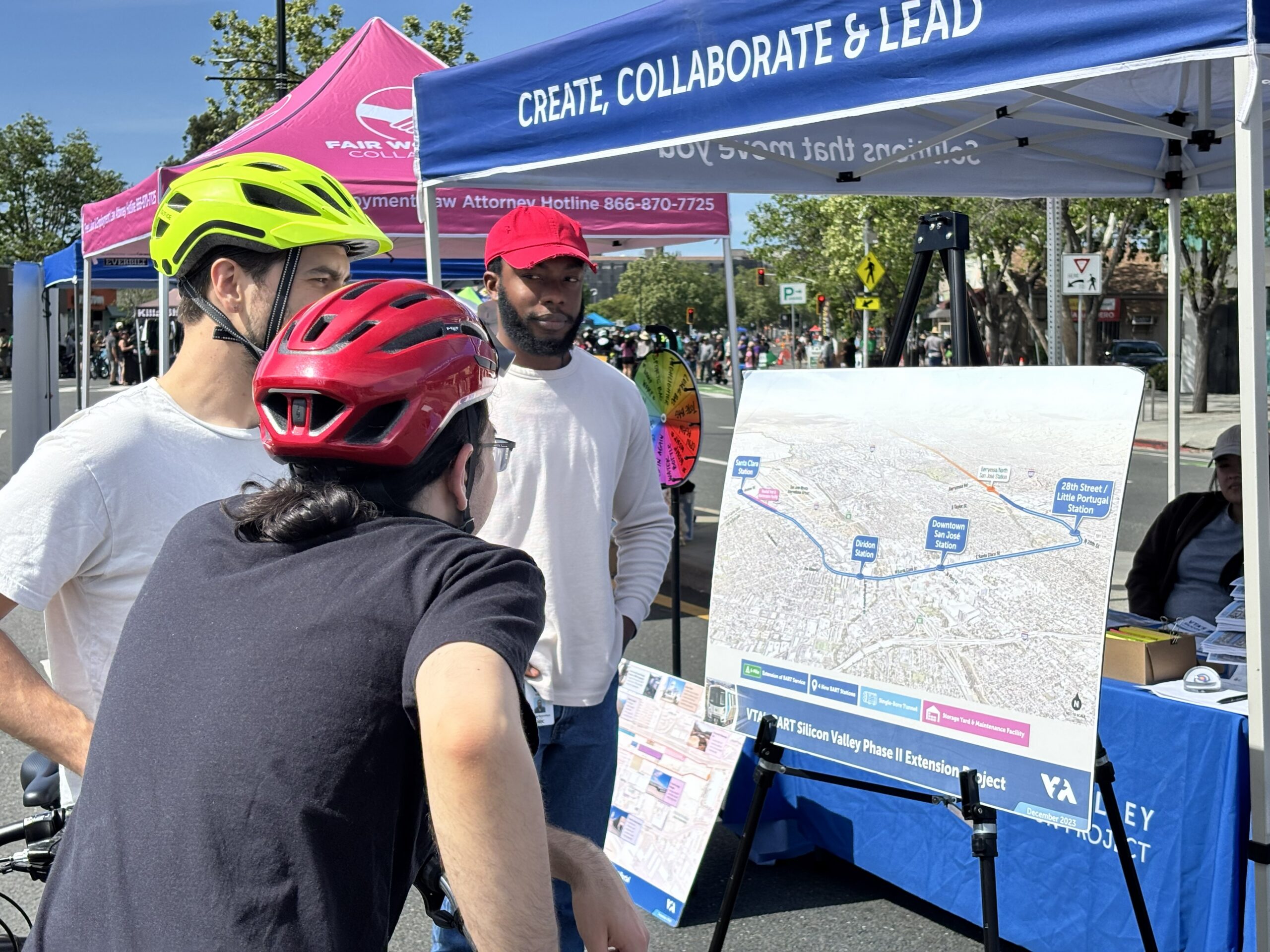 Two cyclists look at a map of the BSVII alignment at the Viva Calle festival.