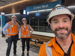 Three construction workers pose in front of newly built subway station in Sydney, Australia